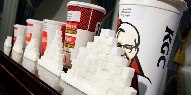 Various size cups and sugar cubes are displayed at a news conference at New York's City Hall, Thursday, May 31, 2012. New York Mayor Michael Bloomberg is proposing a ban on the sale of large sodas and other sugary drinks in the city's restaurants, delis and movie theaters in the hopes of combating obesity, an expansion of his administration's efforts to encourage healthy behavior by limiting residents' choices. (AP Photo/Richard Drew)