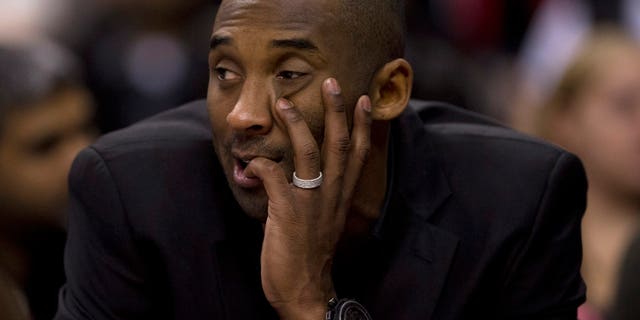 Los Angeles Lakers' Kobe Bryant watches from the sideline during first-half NBA basketball game action against the Toronto Raptors in Toronto, Sunday, Jan. 19, 2014. Bryant injured his left knee in December. (AP Photo/The Canadian Press, Frank Gunn)