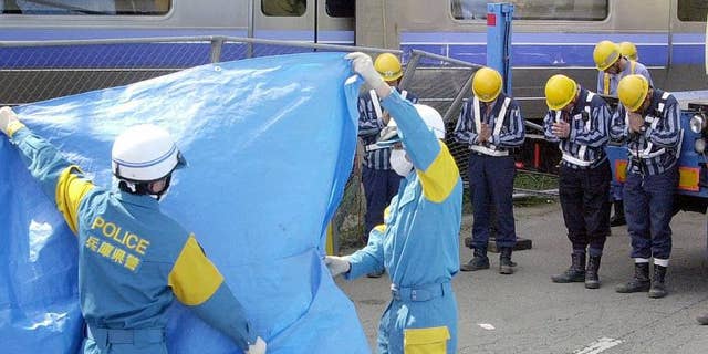 Japan Railway West (JR West) workers offer prayers to a dead body at the site of the train crash in Amagasaki in April 2005. Three former presidents of JR West have been cleared of responsibility for the 2005 train crash that killed over 100 people.