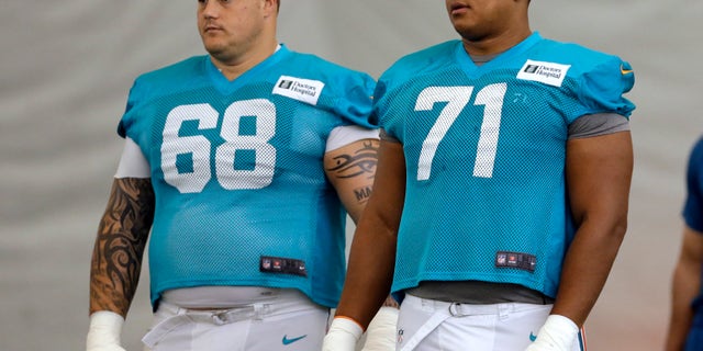 FILE - In this July 24, 2013, file photo, Miami Dolphins guard Richie Incognito (68) and tackle Jonathan Martin (71) stand on the field during NFL football practice in Davie, Fla. Incognito has lashed out at Martin on Twitter, saying "The truth is going to bury you and your entire 'camp.' You could have told the truth the entire time." Incognito also wrote Martin told him he thought about committing suicide last May because he wasn't playing well. Incognito's series of tweets Wednesday, Feb. 12, 2014, directed at Martin and his representatives come as the NFL is preparing to release a report on the Dolphins' bullying case which could shed light on their relationship. (AP Photo/Lynne Sladky, File)