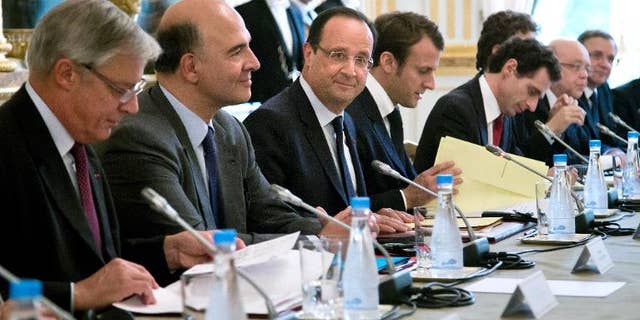 French President Francois Hollande (C) and French Finance Minister Pierre Moscovici (2nd L) attend a meeting with the Board of Governors of the European Central Bank, on October 1, 2013, at the Elysee presidential palace in Paris