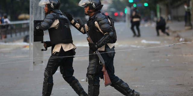 CARACAS, VENEZUELA - MARCH 06: Venezuelan national policemen advance on anti-government demonstrators on March 6, 2014 in Caracas, Venezuela. Protesters continued to stage demonstrations nationwide against high inflation and crime. (Photo by John Moore/Getty Images)