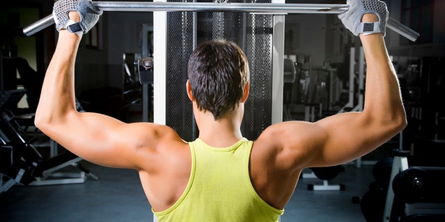 health club: man in a gym doing weight lifting