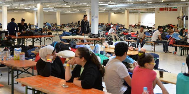 Refugees rest in a former furniture factory after crossing the border from Austria in Freilassing, southern Germany, Thursday, Sept. 17, 2015. (AP Photo/Kerstin Joensson)