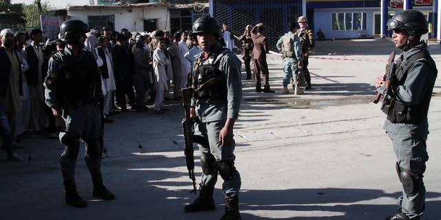 Afghan police soldiers inspect the site of a suicide attack in Kabul, Afghanistan, Monday, June 20, 2016. At least a dozen Nepalese security guards of a foreign logistic company were killed Monday when a Taliban suicide bomber targeted their minibus in the Afghan capital, interior ministry and an Afghan security official said. (AP Photo/Rahmat Gul)