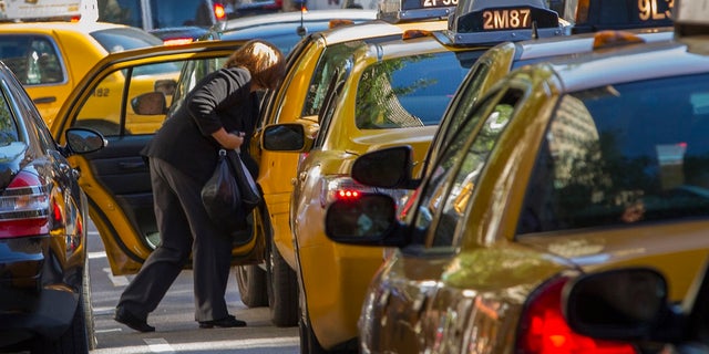 A woman exits a taxi on Third Avenue in heavy traffic caused by road closures due to high security and official motorcades during the United Nations General Assembly, in New York, September 24, 2013. REUTERS/Zoran Milich (UNITED STATES - Tags: POLITICS) - RTX13XSU