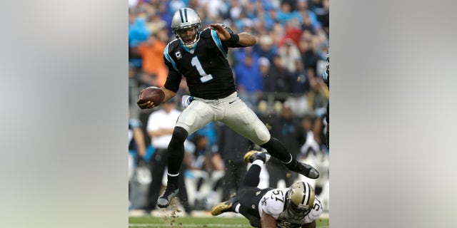 ADVANCE FOR WEEKEND OF JAN. 11-12 - FILE - In this Dec. 22, 2013, file photo, Carolina Panthers' Cam Newton (1) hurdles New Orleans Saints' David Hawthorne (57) in the second half of an NFL football game in Charlotte, N.C. With all the passing NFL teams do these days, it is easy to forget that there is still a place for the run game. (AP Photo/Bob Leverone, File)