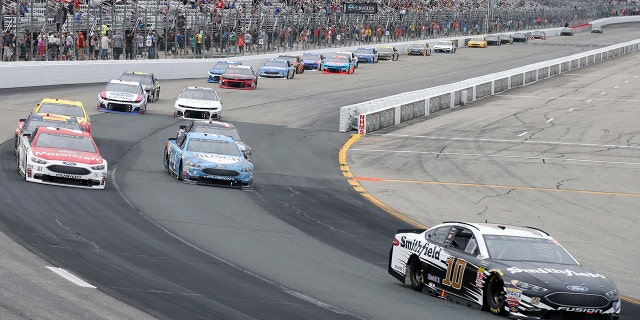 Aric Almirola (10) races ahead of Paul Menard, top left, and Kevin Harvick during the NASCAR Cup Series auto race Sunday, July 22, 2018, at New Hampshire Motor Speedway in Loudon, N.H. (AP Photo/Mary Schwalm)