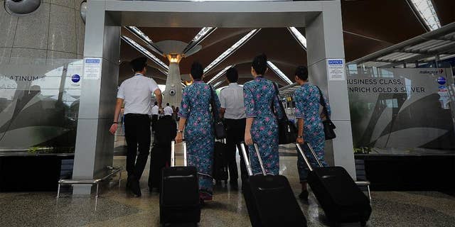 FILE - In this April 10, 2014, file photo, a Malaysia Airlines crew walks into a check in area at Kuala Lumpur International Airport in Sepang, Malaysia. New Malaysia Airlines CEO, Christoph Mueller, 52, comes to the post fresh from a stint reviving Ireland’s Aer Lingus. Mueller will be the first foreigner to head the Malaysian state-owned company. Analysts say he’s an industry veteran “battle hardened” from his work carrying out corporate restructurings at other state-owned airlines, including failed Belgian carrier Sabena. (AP Photo/Joshua Paul, File)