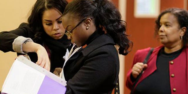 Jan. 28, 2012: Job seekers Cameo Taylor, left, and Angelique McGuire, center, both of San Francisco, wait in line to register at a Career Fair event in San Francisco.