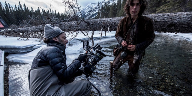 This photo provided by courtesy of Twentieth Century Fox shows, cinematographer Emmanuel Lubezki , left, and Forrest Goodluck as Hawk on set for the film, "The Revenant," directed by Alejandro Gonzalez Inarritu. No name is more feverishly celebrated in Hollywood right now than "Chivo." That's the nickname of the famed cinematographer Lubezki, whose acrobatic long-takes and luminous natural images of natural light have made him revered -- and may make him a three-peat Oscar winner for "Gravity," ''Birdman" and now "The Revenant." The Oscars will be presented on Feb. 28, 2016, in Los Angeles. (Kimberley French/Twentieth Century Fox via AP)