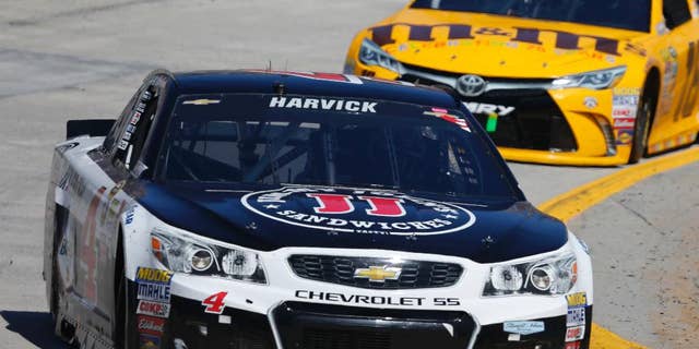 Driver Kevin Harvick (4) leads Kyle Busch (18) into Turn 4 during the Sprint Cup auto race at Martinsville Speedway on Sunday, April 3, 2016, in Martinsville, Va. (AP Photo/Steve Helber)