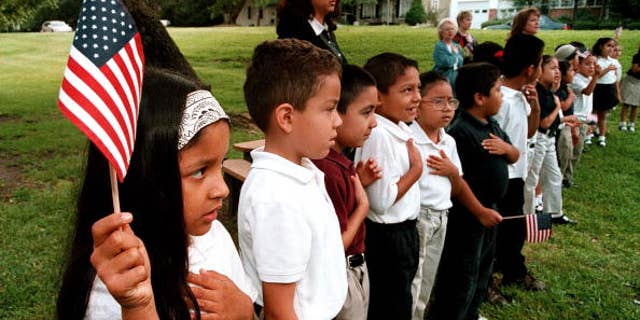 TYLER,TX - SEPTEMBER 11:  A class of Hispanic students recites the Pledge of Allegiance during a September 11 memorial service at Birdwell Elementary School September 11, 2003 in Tyler, Texas. Birdwell has a student body of 600 youngsters, with 60 percent of them being Hispanic. Among the other schools in the Tyler Independent School District, 30 percent of the 17,550 students are Hispanic, according to school district administrators.  (Photo by Mario Villafuerte/Getty Images)