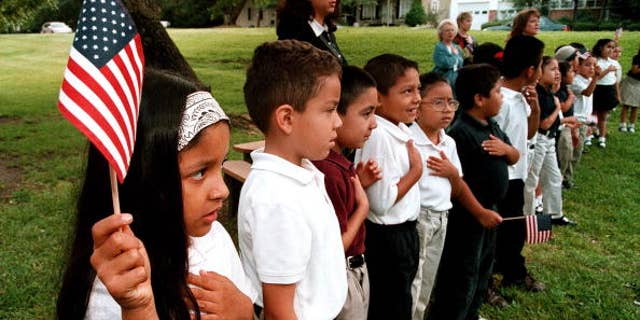 TYLER,TX - SEPTEMBER 11: A class of Hispanic students recites the Pledge of Allegiance during a September 11 memorial service at Birdwell Elementary School September 11, 2003 in Tyler, Texas. Birdwell has a student body of 600 youngsters, with 60 percent of them being Hispanic. Among the other schools in the Tyler Independent School District, 30 percent of the 17,550 students are Hispanic, according to school district administrators. (Photo by Mario Villafuerte/Getty Images)