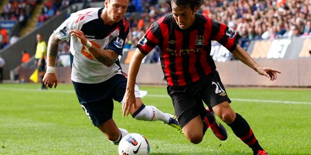 Manchester City's David Silva, right, vies for the ball against Bolton's Gretar Steinsson during their English Premier League soccer match at the Reebok Stadium, Bolton, England, Sunday Aug. 21, 2011. (AP Photo/Tim Hales)