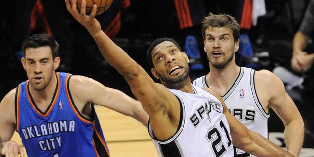 San Antonio Spurs forward Tim Duncan (21) grabs a rebound as Oklahoma City Thunder forward Nick Collison (4) and Spurs forward Tiago Splitter, of Brazil, watch during the first half of Game 2 of the Western Conference finals NBA basketball playoff series, Wednesday, May 21, 2014, in San Antonio. (AP Photo/Darren Abate)