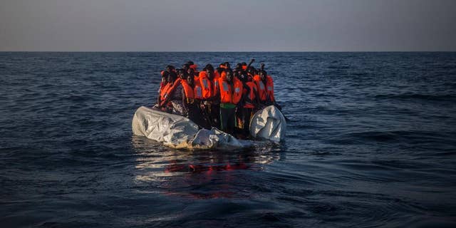 In this photo taken on Saturday Sept. 10, 2016, African refugees and migrants wait aboard a partially punctured rubber boat to be assisted, during a rescue operation on the Mediterranean Sea, about 13 miles North of Sabratha, Libya. (AP Photo/Santi Palacios)