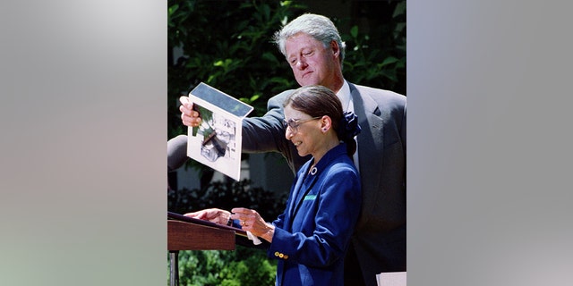 President Clinton lifts a photo away during comments by Judge Ruth Bader Ginsburg after announcing June 14 that he is nominating her to the Supreme Court, 1993.