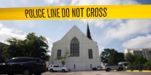 FILE - In this Friday, June 19, 2015 file photo, police tape surrounds the parking lot behind the AME Emanuel Church, a predominantly black church, as FBI forensic experts work at the crime scene where nine people where shot by white suspect Dylann Storm Roof, 21, on Wednesday in Charleston, S.C. The FBI collects extensive data on hate crimes each year, but nearly 2,800 local law enforcement agencies are not submitting the information, according to an investigation of 2009-2014 data by The Associated Press. Thousands more file reports with the FBI only sporadically. (AP Photo/Stephen B. Morton, File)