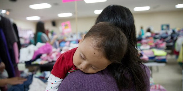 In this April 30, 2105 photo, Gladys Pina, 30, from Honduras holds her 8-month old baby girl at a respite center run by Catholic Charities in McAllen, Texas. She was among nearly two-dozen immigrant mothers who arrived at the center after being released by Border Patrol. Rather than getting locked up in a family detention facility, some families are released by Border Patrol with notices to appear in immigration court. (AP Photo/Seth Robbins)