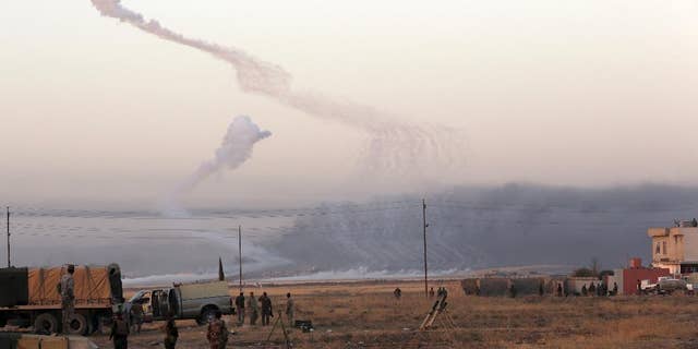 Smoke rises in nearby Mosul as Iraq's elite counterterrorism forces advance towards the city, Iraq, Thursday, Oct. 20, 2016. Iraqi special forces charged into the Mosul battle Thursday with a pre-dawn advance on a nearby town held by the Islamic State group, a key part of a multi-pronged assault on eastern approaches to the besieged city. (AP Photo/Khalid Mohammed)