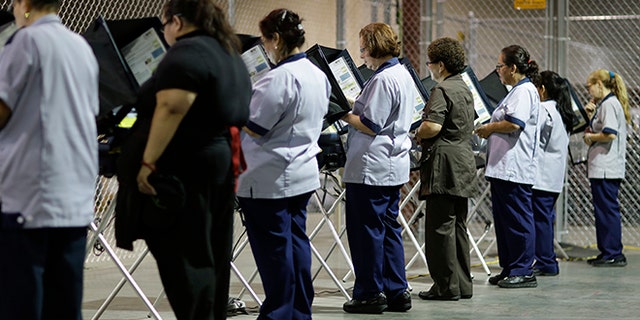 FILE--In this Oct. 26, 2016, file photo, casino workers vote at an early voting site in Las Vegas. Nevada's top election official said Friday the state will provide public voter information requested by a White House commission that is investigating claims of voter fraud in the 2016 election, but will not turn over information such as Social Security numbers of voters and who people voted for. (AP Photo/John Locher, file)