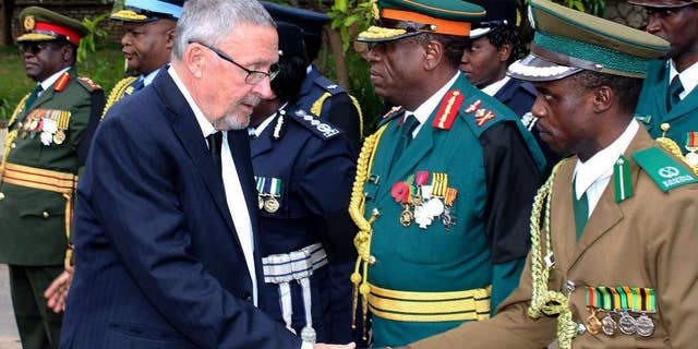 Zambia's vice president Guy Scott greets defense and security chiefs shortly after taking over as acting president, following the death in London on late Tuesday of President Michael Sata, Lusaka, Wednesday, Oct. 29, 2014. Scott, a white Zambian of Scottish descent, became the country's acting president on Wednesday, making him the first white leader of a sub-Saharan African nation since F.W. de Klerk, the apartheid-era head of South Africa who was voted out of power in 1994. (AP Photo)