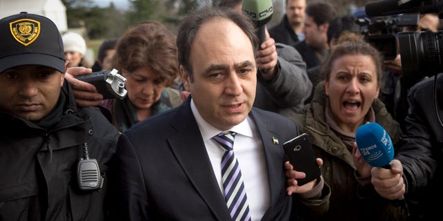 Monzer Akbik, center, a spokesman of the Syrian National Coalition, Syria's main political opposition group, is surrounded by journalists after a meeting with the Syrian government at the United Nations headquarters in Geneva, Switzerland, Sunday, Jan. 26, 2014. Syrians on opposite sides of their country’s civil war tried again Sunday to find common ground, with peace talks focusing on an aid convoy to a besieged city that once more came under mortar attack from the government. (AP Photo/Anja Niedringhaus)