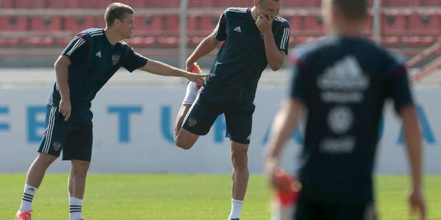 Igor Denisov, left, and Vasily Berezutsky share a joke during the training session of Russian national soccer team in Itu, Brazil, on Sunday, June 15, 2014. Russia will play in group H of the 2014 soccer World Cup. (AP Photo/Ivan Sekretarev)