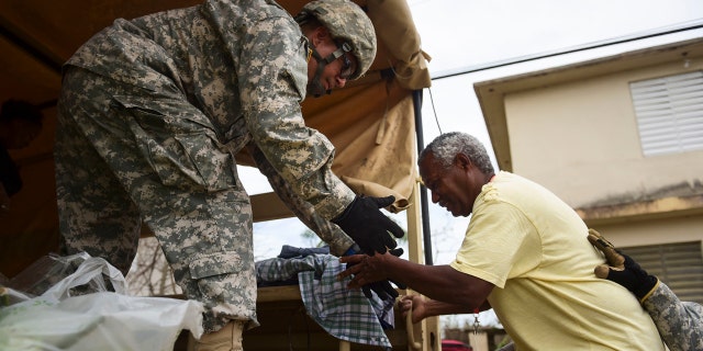 National Guard personnel evacuate Toa Ville resident Luis Alberto Martinez after the passing of Hurricane Maria, in Toa Baja, Puerto Rico, Sept. 22, 2017.