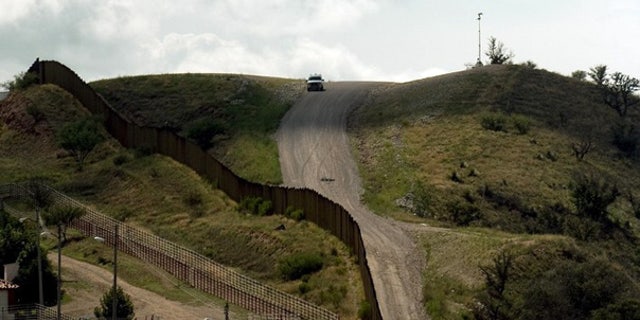 July 28: A U.S. Border Patrol vehicle drives along the fence separating the U.S. from Mexico, near Nogales, Sonora, Mexico.