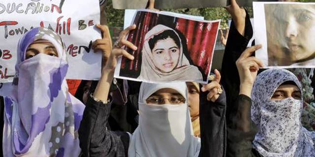 October 10, 2012: Pakistani members of Minhaj-ul-Quran Women League hold up pictures of 14-year-old schoolgirl Malala Yousufzai in Lahore, Pakistan.