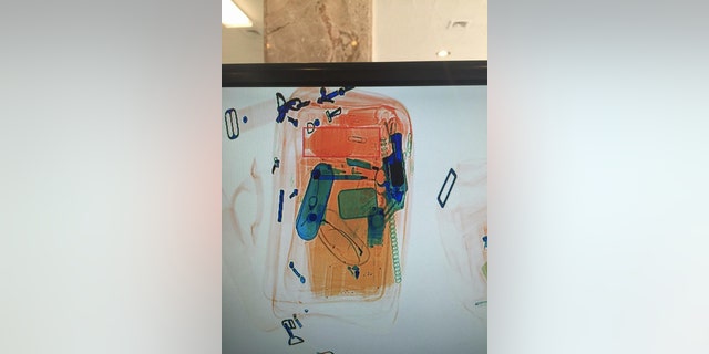 In this photo provided by the Detroit Police Department, an x-rayed photo shows what appears to be a revolver, in blue at right, among other contents of a briefcase that passed through security at the Coleman A. Young Municipal Center in Detroit on Monday, June 20, 2016. Police locked down the adjacent buildings and evacuated workers and visitors. The two buildings are connected by a lobby and house some Wayne County courtrooms and city of Detroit offices, including the mayor’s office and City Council. (Detroit Police Department via AP)