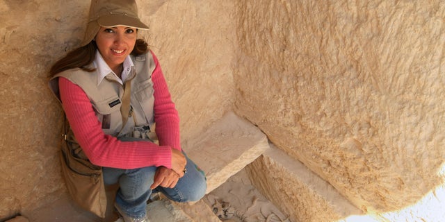 Kathleen Martinez, an Egyptologist from the Dominican Republic, sits near a grave found at the temple of Tasposiris Magna near Borg al-Arab, 50 kms (30 miles) west of Alexandria, on April 19, 2009. Archaeologists searching for the tomb of Marc Anthony and Cleopatra may be closer to locating the burial site of the legendary lovers, Egypt's antiquities council said. A team led by antiquities chief Zahi Hawass and Martinez believes the tomb may be located in three possible sites near the temple and will excavate the three locations next week. AFP PHOTO/CRIS BOURONCLE (Photo credit should read CRIS BOURONCLE/AFP/Getty Images)