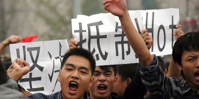 Anti-Japan protesters march with cards calling for a boycott of Japanese products in Wuhan in central China's Hubei province Monday, Oct. 18, 2010. Thousands of Chinese have marched in different Chinese cities in sometimes violent protests since Saturday against Japan and its claim to disputed islands, a show of anger far larger than past protests over the competing territorial claims.