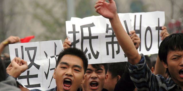 Anti-Japan protesters march with cards calling for a boycott of Japanese products in Wuhan in central China's Hubei province Monday, Oct. 18, 2010. Thousands of Chinese have marched in different Chinese cities in sometimes violent protests since Saturday against Japan and its claim to disputed islands, a show of anger far larger than past protests over the competing territorial claims.