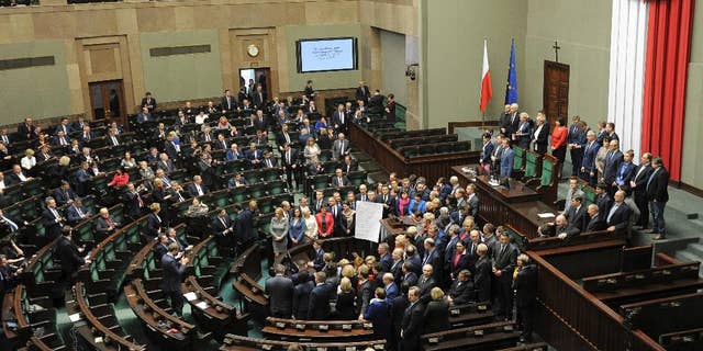 A general view of the parliament session hall as opposition lawmakers gather around the podium with a list of ten freedoms that they say are violated by the ruling party, as they end their protest, in Warsaw, Poland, Thursday, Jan. 12, 2017. Opposition parties blocked the session hall since Dec. 16 to protest a budget that according to them was passed illegally. (AP Photo/Alik Keplicz)