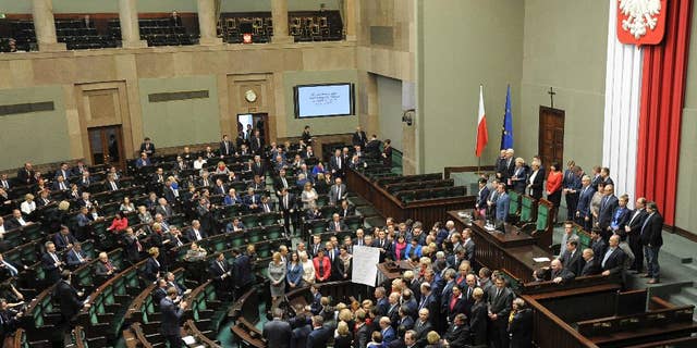A general view of the parliament session hall as opposition lawmakers gather around the podium with a list of ten freedoms that they say are violated by the ruling party, as they end their protest, in Warsaw, Poland, Thursday, Jan. 12, 2017. Opposition parties blocked the session hall since Dec. 16 to protest a budget that according to them was passed illegally. (AP Photo/Alik Keplicz)