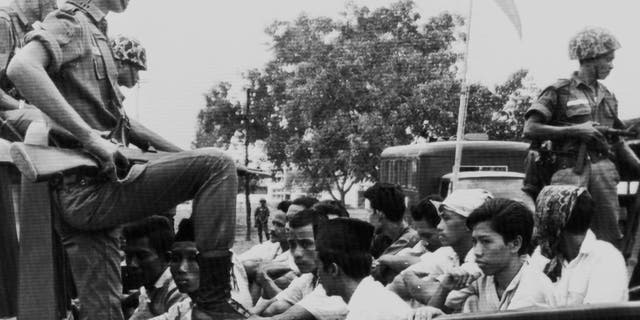 In this Oct. 30, 1965, file photo, members of the Youth Wing of the Indonesian Communist Party (Pemuda Rakjat) are watched by soldiers as they are taken to prison in Jakarta following a crackdown on communists after an abortive coup against President Sukarno's government earlier in the month.