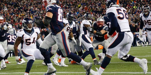 New England Patriots tight end Rob Gronkowski, center, catches a touchdown pass from quarterback Tom Brady between Denver Broncos outside linebackers Brandon Marshall (54) and Von Miller (58) in the second half of an NFL football game on Sunday, Nov. 2, 2014, in Foxborough, Mass. (AP Photo/Elise Amendola)