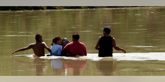 FILE: Undated: Unidentified people in Mexico crossing the Rio Grande to enter the United States illegally, in Nuevo Laredo, Mexico.