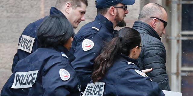 Former Kosovo prime minister Ramush Haradinaj, right, is rushed by police officers inside the Colmar courthouse, eastern France, Thursday Jan.5, 2017. Haradinaj is facing possible extradition to Serbia to face war crimes charges after being arrested at a French airport. (AP Photo/Jean-Francois Badias)