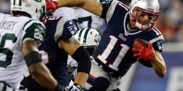FILE - In this Sept. 13, 2013, file photo, New England Patriots wide receiver Julian Edelman (11) runs past New York Jets strong safety Dawan Landry (26) during the second quarter of an NFL football game in Foxborough, Mass. Edelman surprisingly emerged as the Patriots top receiver last season. And he says he won't change just because he signed a big contract in the offseason. (AP Photo/Elise Amendola, File)