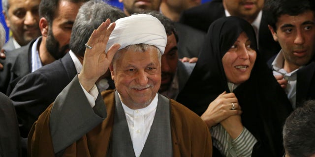 In this Saturday, May 11, 2013 photo, former President Akbar Hashemi Rafsanjani, waves to media, as he registers his candidacy for the upcoming presidential election, while his daughter Fatemeh, smiles at second right, at the election headquarters of the interior ministry in Tehran, Iran. On Saturday Rafsanjani's made a last minute surprise decision to enter Iran's presidential election process, which now includes more than 680 hopefuls and will culminate June 14 with just a handful of names on the ballot to succeed Mahmoud Ahmadinejad. In one of his first statements since joining the race, Rafsanjani spoke in general terms Sunday of seeking a new ``economic and political'' rebirth in a time of ``foreign threats and sanctions.'' (AP Photo/Ebrahim Noroozi)
