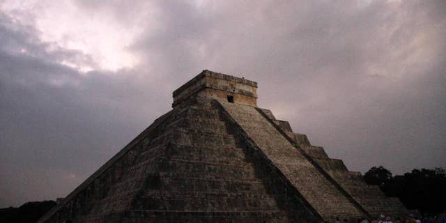 FILE - In this Dec. 21, 2012 file photo, people gather in front of the Kukulkan temple in Chichen Itza, Mexico. Mexican experts said Wednesday, Nov. 16, 2016 they have discovered what may be the original structure at the pyramid of Kukulkan at the Mayan ruins of Chichen Itza. (AP Photo/Israel Leal, File)