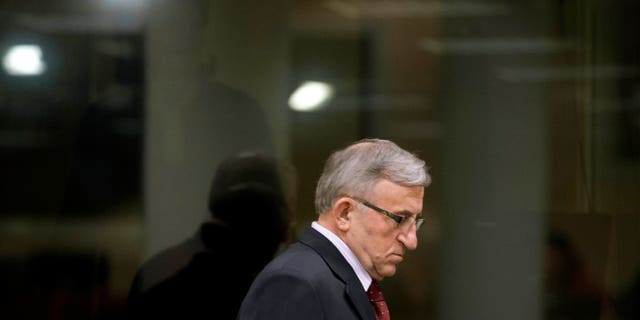 Vladimir Lazarevic enters the Yugoslav war crimes tribunal courtroom in The Hague Thursday, Jan. 23, 2014. Nikola Sainovic, Nebojsa Pavkovic, Sreten Lukic, and Vladimir Lazarevic, four former high-ranking Yugoslav and Serbian political, military and police officials who were convicted in 2009 for crimes committed against Kosovo Albanians in 1999 during Serbia’s deadly crackdown on ethnic Albanians appeared in court at the Yugoslav war crimes tribunal ahead of a decision in their appeal. (AP Photo/Peter Dejong, Pool)