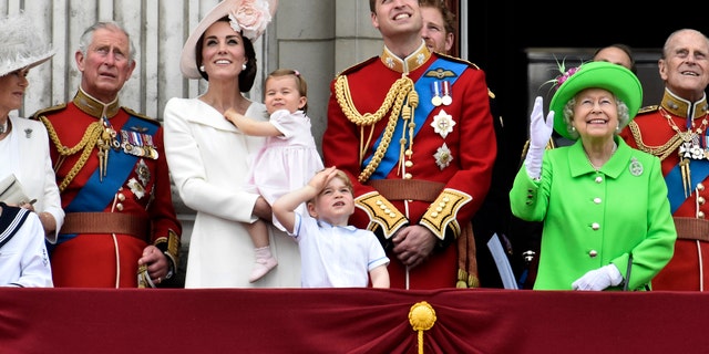 Members of the royal family, including Camilla Duchess of Cornwall, Prince Charles, Catherine, Duchess of Cambridge holding Princess Charlotte, Prince George, Prince William, Queen Elizabeth, and Prince Philip watch a flypast as they stand on the balcony of Buckingham Palace after the annual Trooping the Colour ceremony on Horseguards Parade in central London, on June 11, 2016.