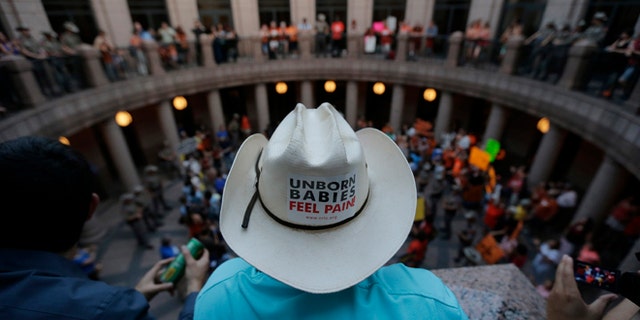 Opponents and supporters of an abortion bill gather in a courtyard outside a hearing for the bill at the state capitol, Tuesday, July 2, 2013, in Austin, Texas. Gov. Rick Perry has called lawmakers back for another special session with abortion on the top of the agenda. (AP Photo/Eric Gay)