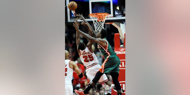 Chicago Bulls' Marquis Teague (25), goes up for a rebound against Milwaukee Bucks' Larry Sanders (8), during the first half of an NBA preseason basketball game in Chicago, Monday, Oct. 21, 2013. (AP Photo/Paul Beaty)