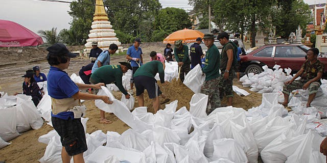 Villagers and soldiers join hands in making sand bags for barricades at a temple in Pak Kred district, Nonthaburi province, Thailand Thursday, Oct. 13, 2011. The ongoing floods is the worst to hit the Southeast Asian nation in decades. About 8.2 million people in 60 of Thailand's 77 provinces have been affected by floods and mudslides, and 30 provinces are currently inundated.